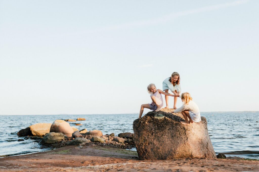 Children playing on a rock at Kotka beach